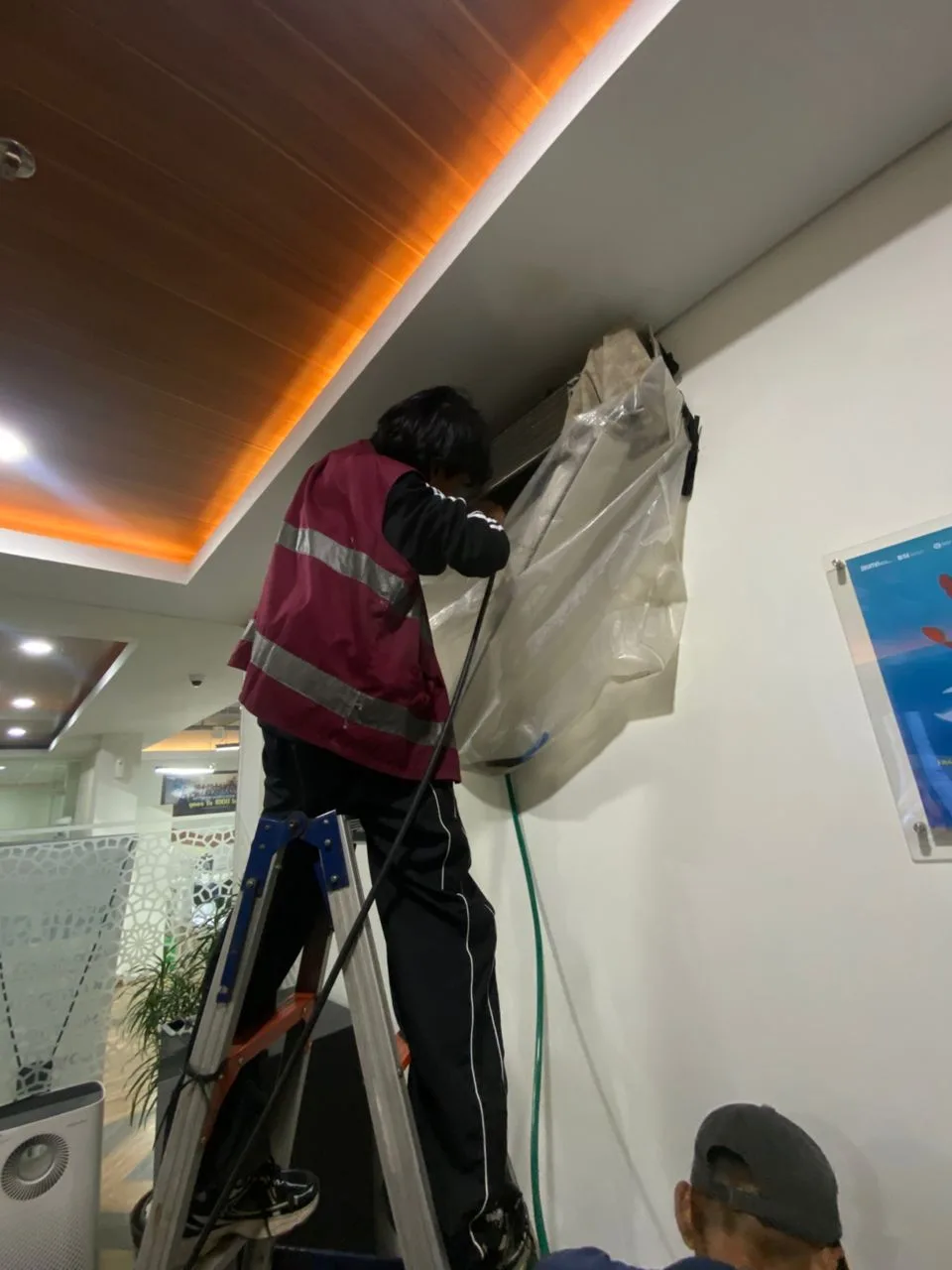 Teknisi mencuci AC indoor menggunakan perlengkapan kerja